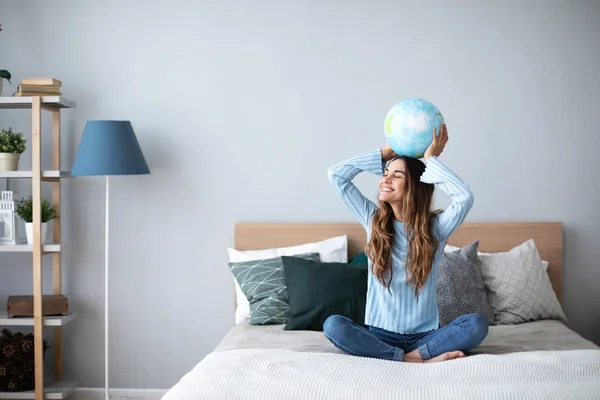 Joven mujer alegre soñando con un viaje sosteniendo un globo modelo ab — Foto de Stock