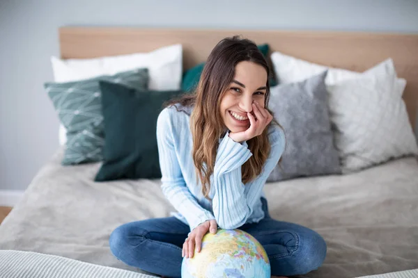 Retrato de uma bela mulher feliz com um globo dentro de casa . — Fotografia de Stock