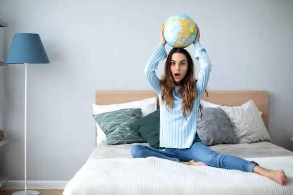 Jovem mulher com modelo globo do mundo em casa . — Fotografia de Stock