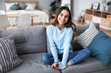 Evdeki kanepede dinlenen güzel bir kadın. Ev hayatı..