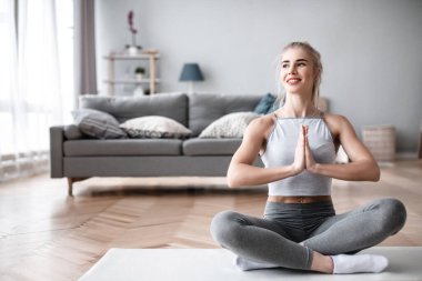 Evde yoga yapan güzel bir genç kadın. Yaşam tarzı kavramı.