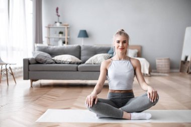 Evde yoga yapan güzel bir genç kadın. Yaşam tarzı kavramı.