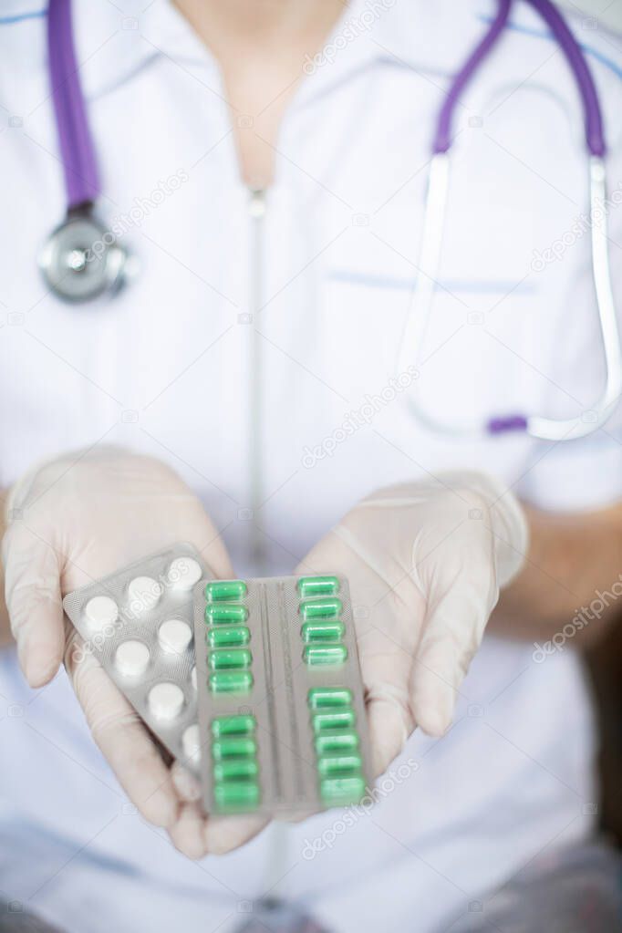 Female doctor holding pills close-up. Medicine and health.