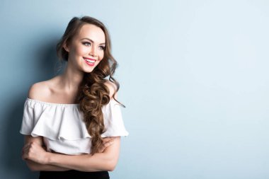 Mavi duvar arkasında gülümseyen genç bir kadın. Güzel bir kızın portresi..