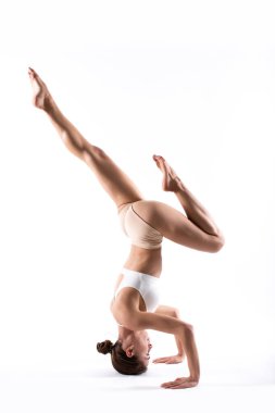 Stüdyoda çalışan genç ve güzel yoga kadını beyazlar içinde izole edilmiş. Sağlıklı yaşam.