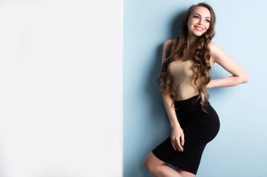 Güzel gülümseyen genç bir kadının portresi, mavi arka planda fotokopi alanı ile..