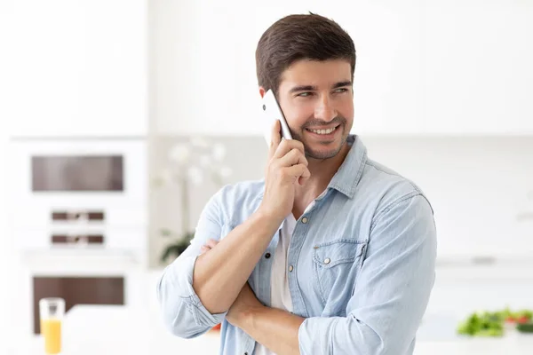 Jovem Homem Bonito Falando Smartphone Cozinha Casa — Fotografia de Stock