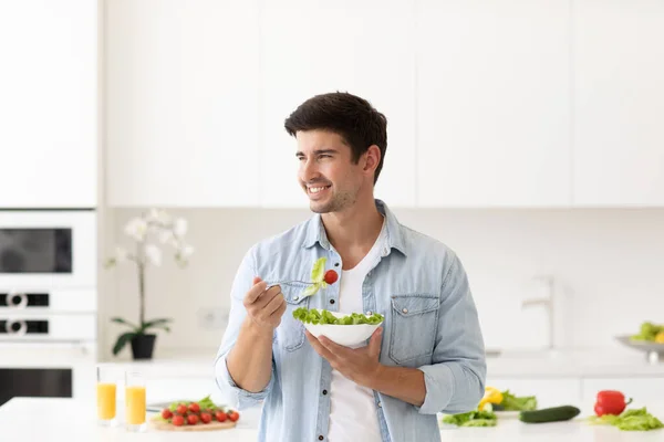 自宅のモダンなキッチンでサラダ新鮮な野菜のプレートと笑顔の男 健康食品のコンセプト — ストック写真