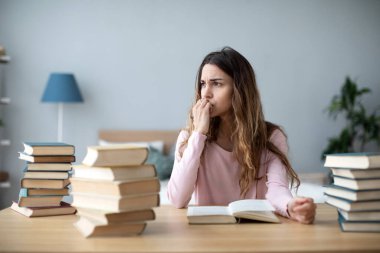 Masada bir sürü kitabı olan yorgun öğrenci kız. Ev ödevi üniversitesi. Okula geri dön..