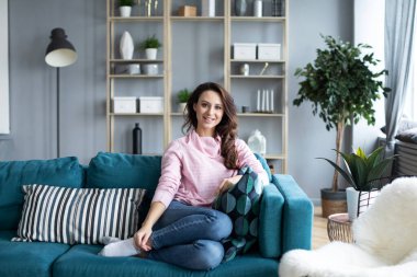 Evdeki rahat bir kanepede dinlenen bir kadın. İçerideki tatlı kız..