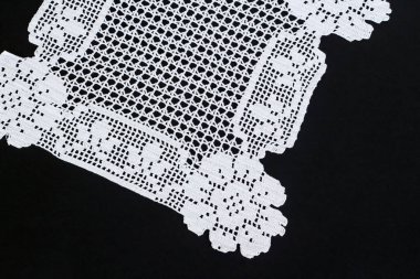 Siyah yüzeyde beyaz renkli el yapımı gül desenli dantel kaplama, üst görünüm