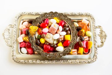 Geleneksel renkli Türk şekerlemeleri ve gümüş şarap tepsisi üzerindeki hazlar, manzaranın üstünde. Bayramların kavramsal görüntüsü.