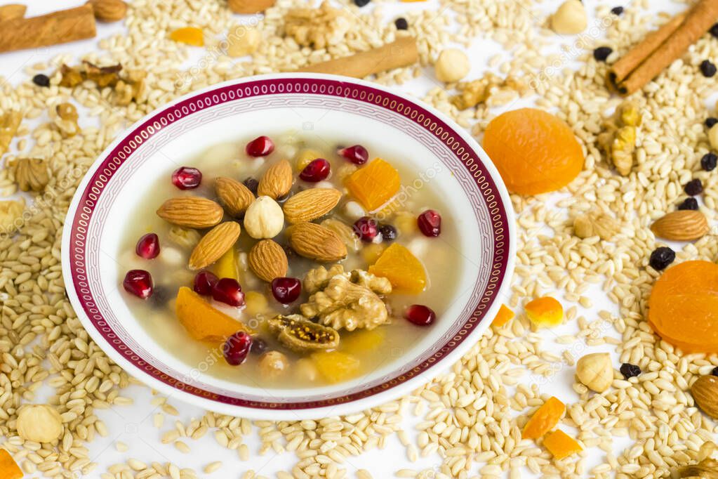 Traditional Turkish Dessert Ashure or Noah's Pudding in white bowl on ingredients of Ashure Dessert