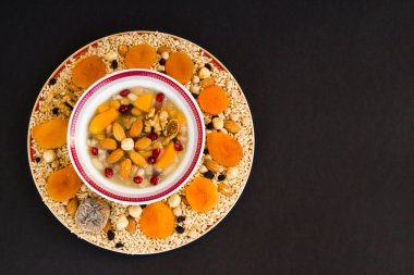 Geleneksel Türk Tatlısı ya da Nuh 'un Pudingi, siyah yüzey üzerinde beyaz kâse şeklinde fotokopi alanı olan çiçek dizayn etti