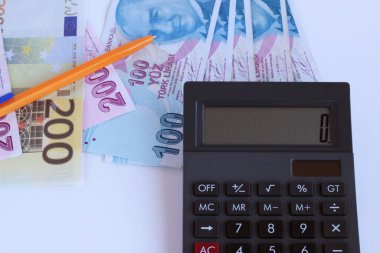 Beyaz yüzeydeki siyah hesap makinesinin sıfır numarasıyla kalem, Türk banknotları, fotokopi alanı ve 200 avroluk banknot