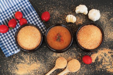 Geleneksel Türk Ev Yapımı Kuru Çorba, Tarhana taneleri ve siyah yüzeyde güveç kasesinde malzemelerle pişirilmiş.
