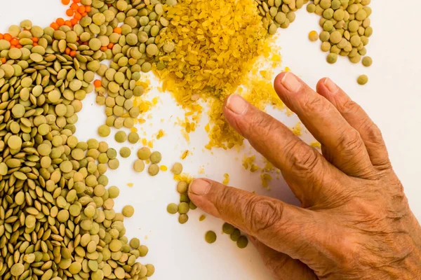 Yeşil mercimek içinde taş var mı diye eski el kontrol ediyor.