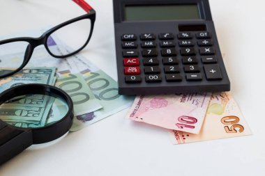 Türk Para Banknotları Avrupa, Dolar Faturası, büyüteç, gözlük ve siyah hesap makinesiyle beyaz yüzey üzerine.
