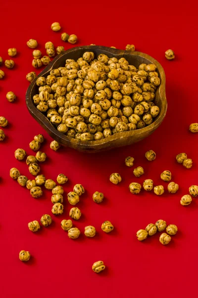 Double Roasted Yellow Chickpeas Wooden Bowl Red Surface Vertical Image — Stock Photo, Image
