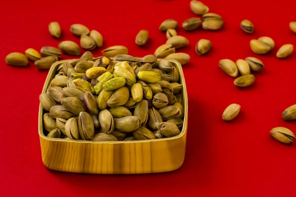 Vers Knapperig Pistachenoten Houten Kom Levendige Rode Achtergrond Close Genomen — Stockfoto