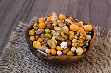 Tahta bir tabakta, kuru, çıtır çıtır, kuru fındıklar ve kuru meyveler.
