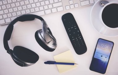 Üstten görünüm bir resepsiyon, kulaklık, klavye, Not defteri ve bir fincan kahve ile çalışma alanı. İşten kır. Uygulanan tahıl etkiler ile stilize çift pozlama görüntü