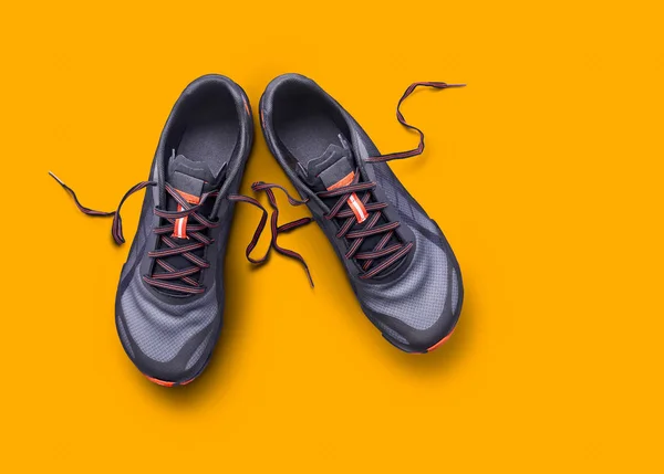 Top view of gray and orange trainers isolated on a yellow backgr — Stock Photo, Image