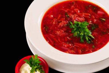 Maydanoz ve ekşi kremayla servis edilen kırmızı borş. Lahana ve pancar çorbası..