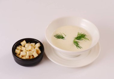 Beyaz kremalı çorba kraker ve dereotla servis edilir. Beyaz arkaplan