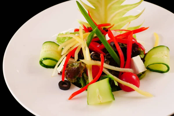Zeleninový salát. Zelí, rajče, okurka, paprika, olivy Černé pozadí — Stock fotografie
