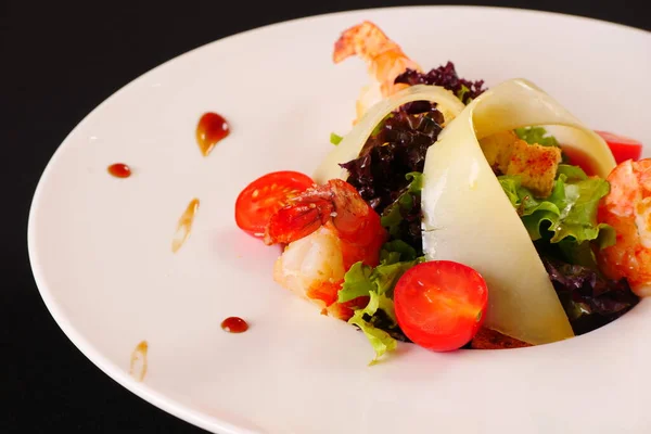 Salada com camarão, queijo, alface, tomate. Fundo preto — Fotografia de Stock