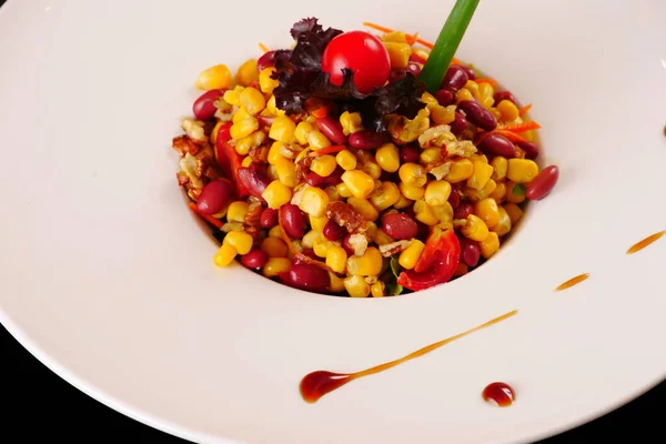 Salada de feijão. Salada com feijão, milho, nozes, carne, tomate. Fundo preto — Fotografia de Stock