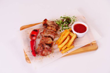 Izgara kuzu pirzolası, biber, domates, patates kızartması, ahşap tahtada ketçap soğan