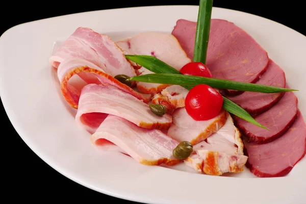 Et tabağı. Pirzola. Jambon, pastırma, tavuk fileto. Siyah arkaplan