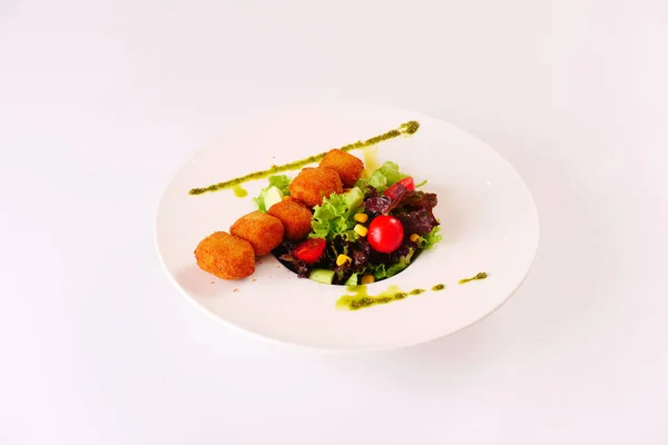 Marul ve domatesle servis edilen peynirli kroket. Beyaz arkaplan