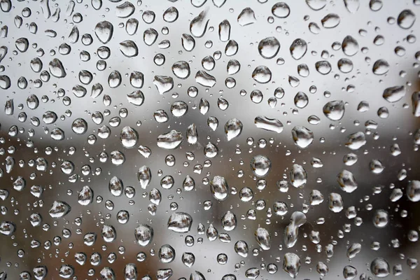 Cam yüzeyde yağmur damlaları. Bir damla suyun dokusu.