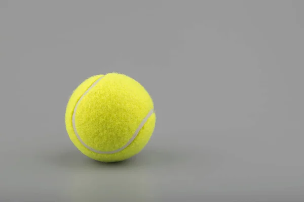 Bola de tênis no fundo cinza — Fotografia de Stock