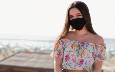 Siyah maskeli bir genç kameraya odaklanıyor.