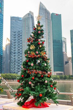 Önünde Noel ağacı olan Marina Körfezi gökdelenlerinin manzarası