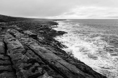 İrlanda 'nın fırtınalı havasında İrlanda uçurumlarının siyah ve beyaz deniz manzarası