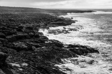 İrlanda 'nın fırtınalı havasında İrlanda uçurumlarının siyah ve beyaz deniz manzarası
