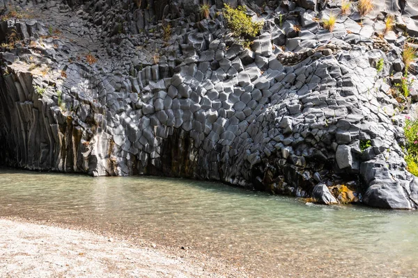 View of basalt rocks, waterfalls and pristine water of Alcantara gorges in Sicily, Italy