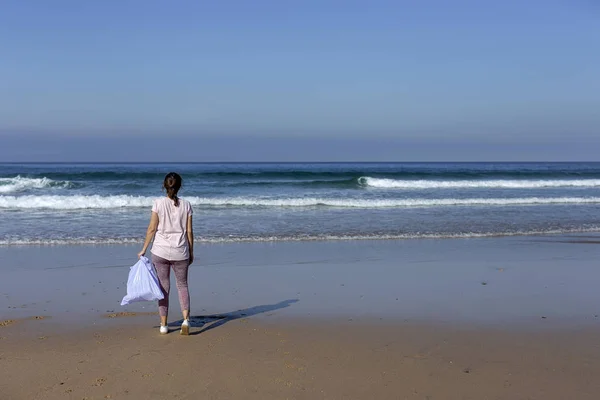 Mujer recogiendo basura y plásticos limpiando la playa —  Fotos de Stock