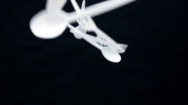 Renkli arka planlarda plastik çatal bıçak seti var. Kaşıklar, çatallar. Düz yatıyordu. Üst görünüm