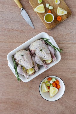 Çiğ koquelet tavukları sebze ve aromatik otlarla kızartılmaya hazır. limon, pırasa ve havuç.