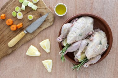 Çiğ koquelet tavukları sebze ve aromatik otlarla kızartılmaya hazır. limon, pırasa ve havuç.