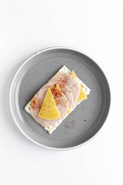 Arka planda sosisli tavuk, peynir ve kırmızı biberli tuzlu krakerler var. Düz yatıyordu. Üst görünüm