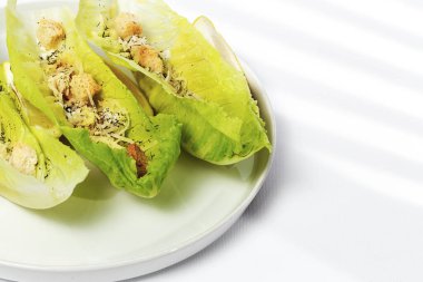 Tavuk, marul, limon, tost, sezar sosu, peynir ve sarımsaklı ev yapımı Sezar salatası. Beyaz arka planda. Sağlıklı gıda kavramı.