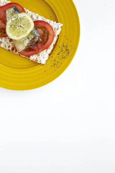 色の背景に上からイワシ トマト レモンを使った塩味のクラッカー 平置きだ トップ表示 — ストック写真