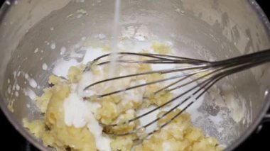 Şef elleri kroketler için ev yapımı beşamel sosu yapıyor.